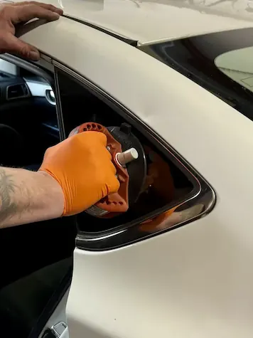 OEM Nissan quarter glass for Nissan Altima being set into opening