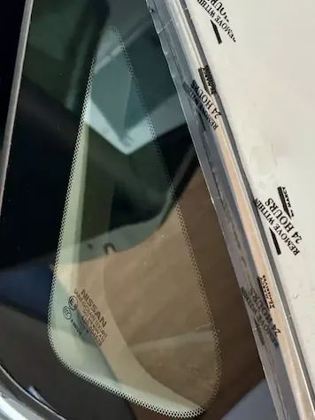 Protective tape applied to installed quarter glass — remove within 24 hours