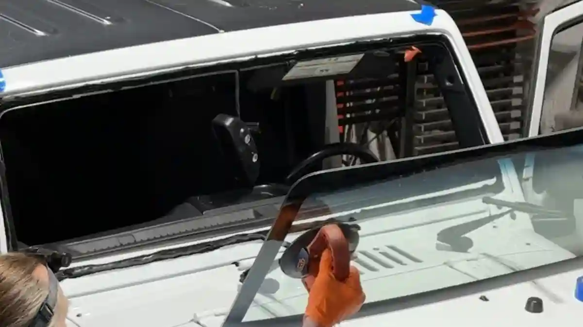 Two technicians setting a new windshield on a Jeep Wrangler at 123 Glass Company in Omaha