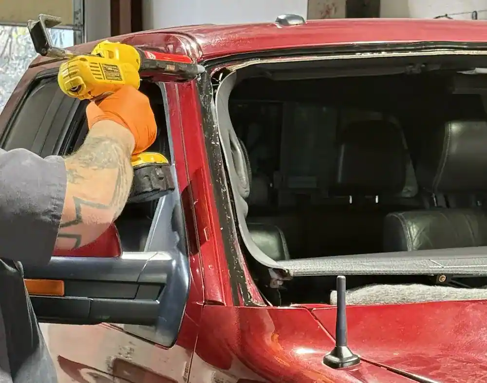 Applying automotive urethane adhesive during windshield installation at 123 Glass Company in Omaha