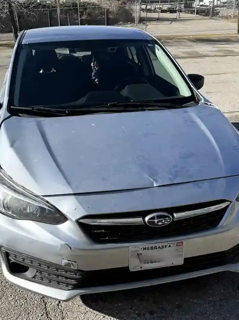 Subaru Impreza after windshield replacement at 123 Glass Company in Omaha — new glass installed, body damage still present.