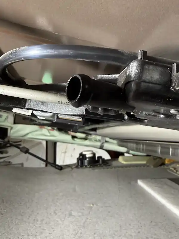 Sunroof drain fitting with hose removed, exposing the drain opening — clog confirmed at this location.