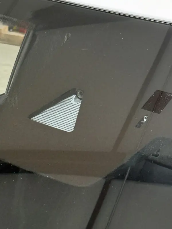 Windshield mounted ADAS camera visible through a trapezoid shaped cutout in the third visor on a second vehicle