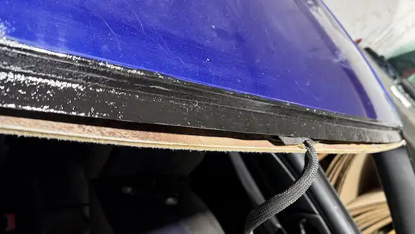 Top rail pinch weld primed and ready for windshield installation on a 2004 Chevy Monte Carlo.