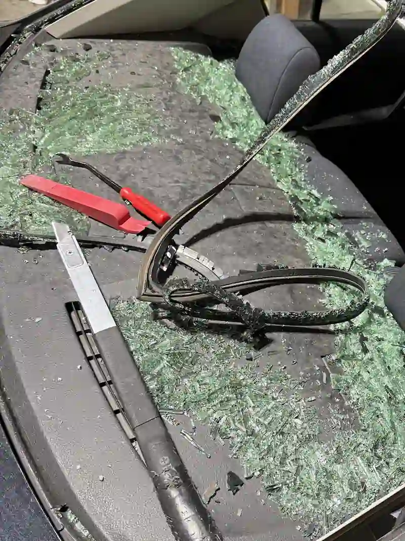 Shattered rear glass on a black sedan before replacement at 123 Glass Company in Omaha