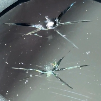 Star crack windshield chip — distinct fractures radiating outward from a single impact point.